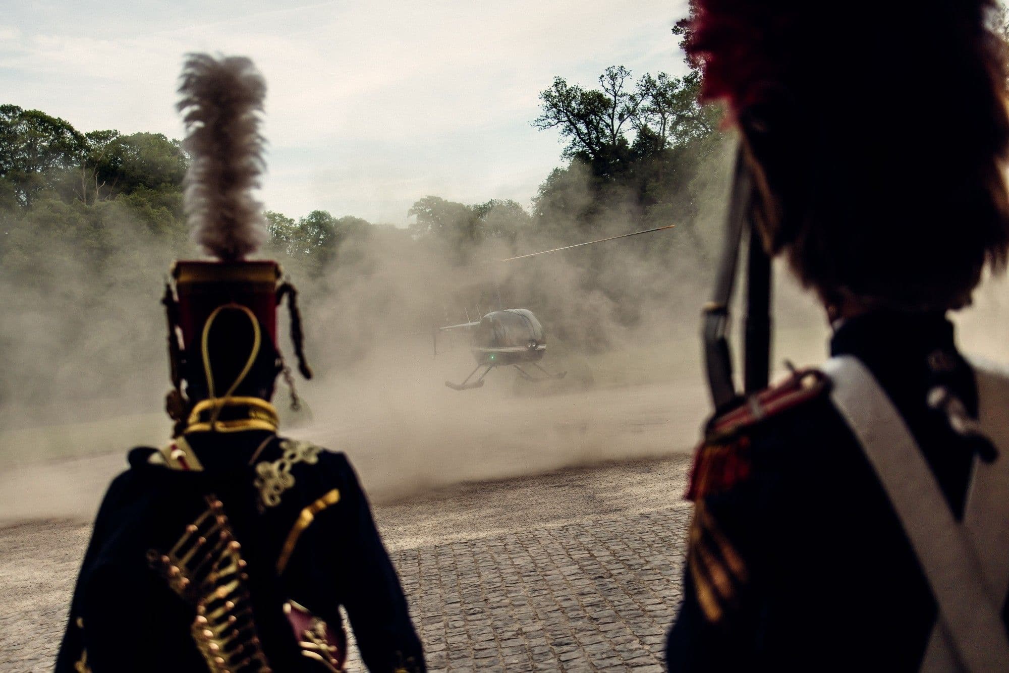 A helicopter landing, greeted by two hussars in uniform